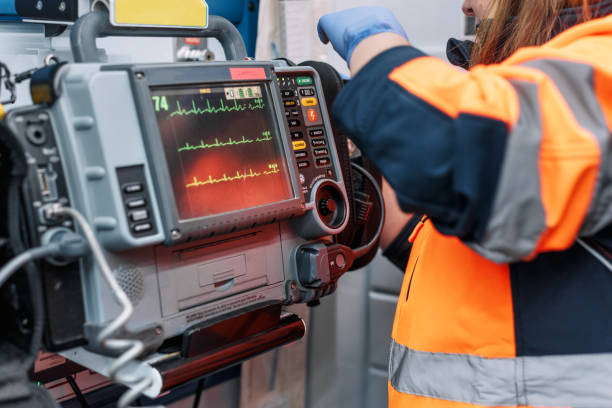Medical urgency in the ambulance. Emergency doctor using defibrillator.