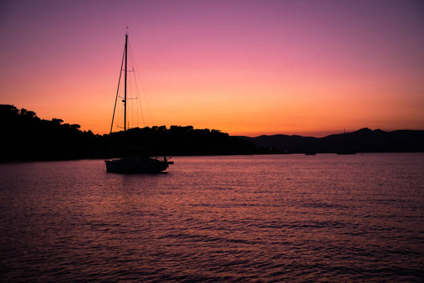 horizontal landscape with sunset at the sea side, nautical vessel in the sea.