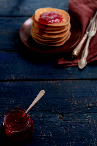 Tasty breakfast. Pancakes with strawberry confiture and butter. Selective focus.