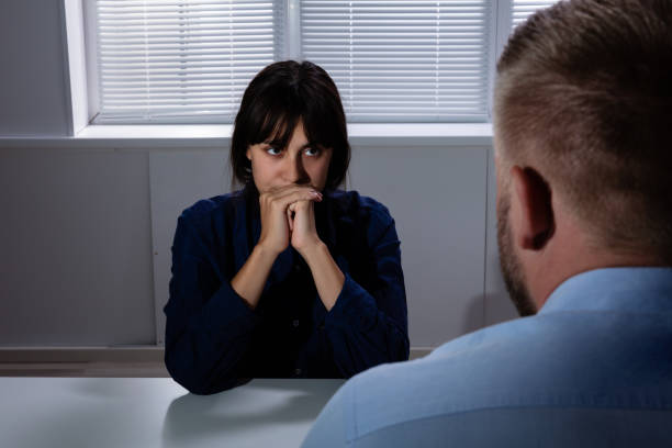 Close-up Of A Man Looking At Sad Woman In Room Man Sitting In Front Of Sad Worried Young Woman Suffering From Depression Looking Away interrogation woman stock pictures, royalty-free photos & images