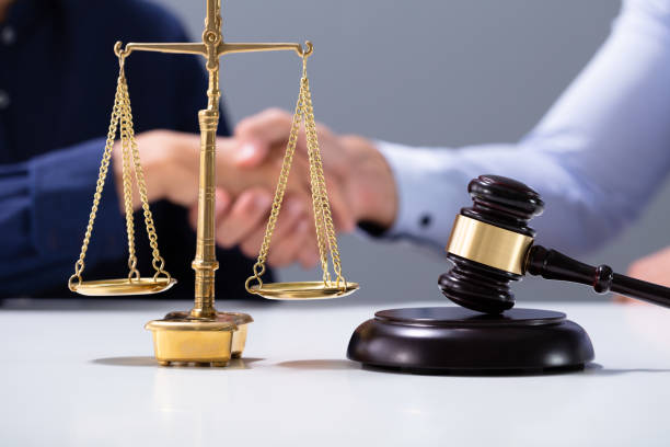 istock Gavel And Golden Justice Scale In Front Of Shaking Hands 1176206688