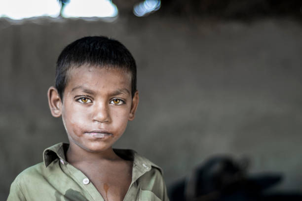 крупным планом бедных глядя голодный мальчик-сирота в лагере беженцев с печальным выражением на лице и его лицо и одежда грязные и глаза по� - hungry child human hand india стоковые фото и изображения