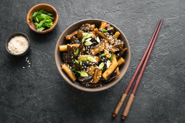 Glazed fried aubergine Stir fried aubergine in bowl. Corean, chinese or asian vegan meal - eggplant stir fry with soy sauce sweet glaze, top view, copy space. campanula nobody green the natural world stock pictures, royalty-free photos & images