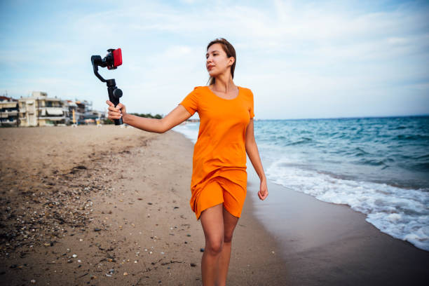 istock Young woman vlogging from beach 1176208575