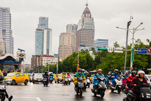 Taiwan, Taipei - May 2019: Motorcyclists commuting in Xinyi District Taipei downtown on a rainy day.