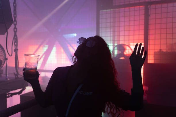silueta de mujer joven bailando en el club de techno - drum & bass fotografías e imágenes de stock