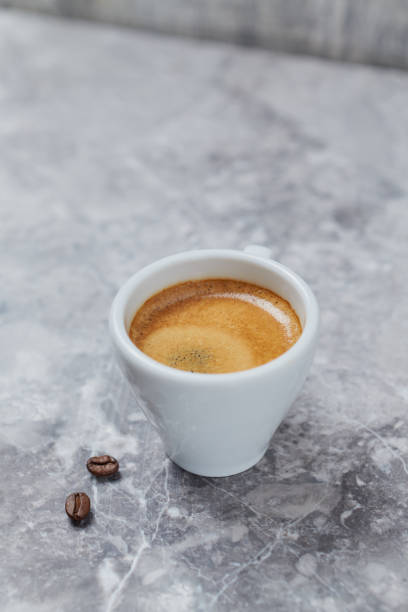 istock Cup of coffee and coffee beans on bright stone background. Copy space 1176226438