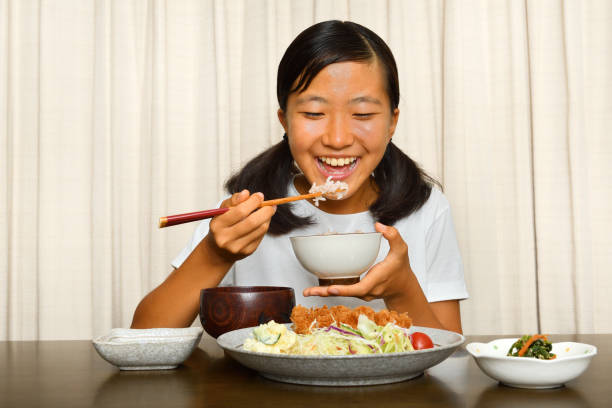 istock Japanese girl enjoys having dinner 1176226924