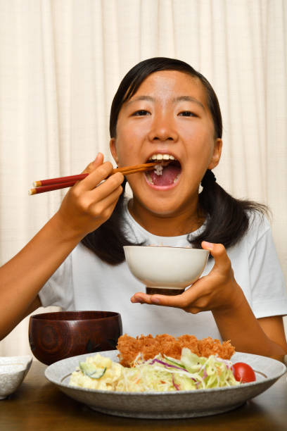 istock Japanese girl enjoys having dinner 1176226984