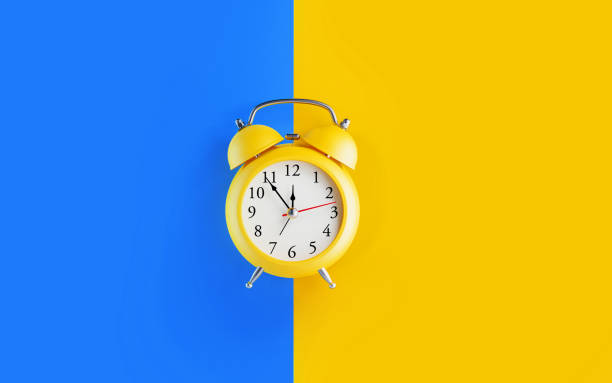 reloj de alarma amarillo sobre fondo azul y amarillo - number alarm clock clock hand old fashioned fotografías e imágenes de stock