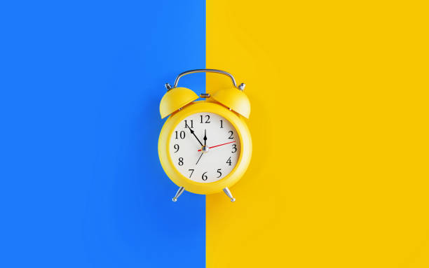 Yellow Alarm Clock over Blue and Yellow Background