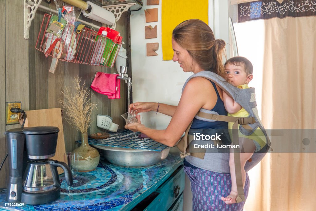 Künstlerin mit ihrer Tochter auf dem Rücken im Atelier der Küche - Lizenzfrei Brasilien Stock-Foto