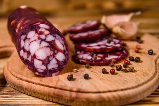 placa de estaca com a salsicha cortada do salami e o alho em uma tabela de madeira - 7651 - fotografias e filmes do acervo