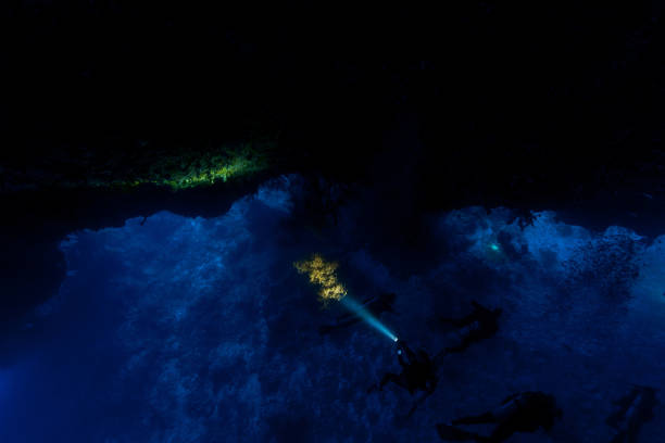 SCUBA Divers Exploring Siaes Tunnel, a Deep Cavern in Palau, Micronesia