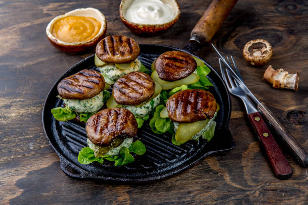 burgers grillés de champignon de bun de portobello sur le pan en fonte de gril ob fond en bois, vue supérieure - appetizer bread breakfast cashew photos et images de collection