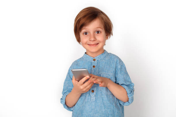 istock Boy studio standing isolated on grey with smartphone looking camera cheerful 1176237534