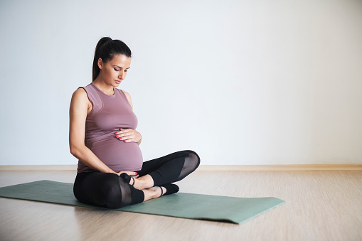 Pregnant woman doing pilates on an exercise mat