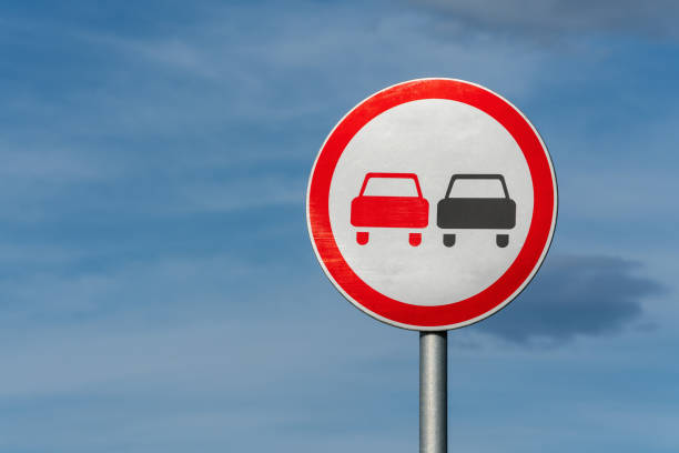 No overtaking road traffic sign with two cars. Information and warning road traffic street sign, compliance with rules stock photo