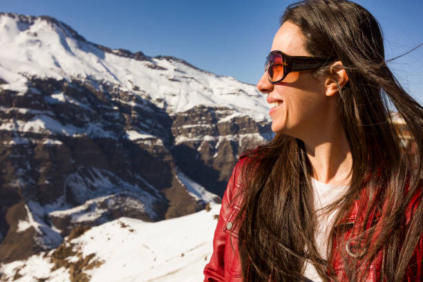 lachende schöne frau mit blick in die schneebedeckten berge in anden gebirge, chile - travel destinations mountain hiking profile stock-fotos und bilder
