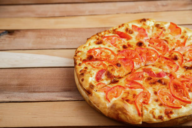 istock medium-sized pizza with tomatoes on a wooden tray 1176244235