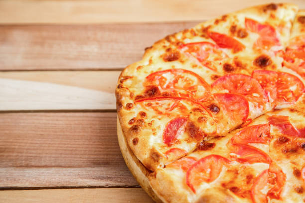 istock medium-sized pizza with tomatoes on a wooden tray 1176248284