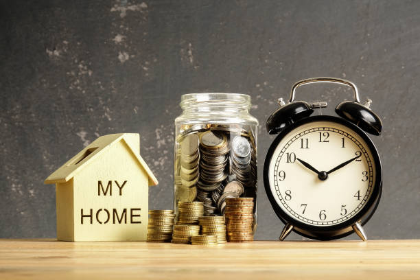 istock Housing saving concept with stacked coins,house model and alarm clock. 1176250117