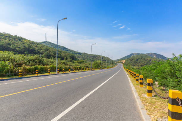 istock Wide road through the mountains under the blue sky and white clouds 1176252054