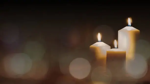 Photo of Christmas advent candle light in church with blurry golden bokeh for religious ritual or spiritual zen meditation, peaceful mind and soul, or funeral ceremony
