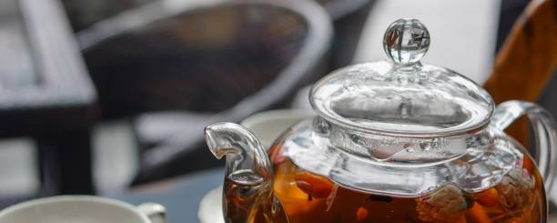 투명 한 유리 주전자와 검은 테이블에 접시와 도자기 컵에 고지 (중국 울프 베리)를 곁들인 향기로운 차 - tea green tea jasmine chinese tea 뉴스 사진 이미지