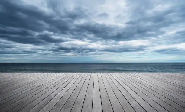 Photo of Wooden jetty at seaside and thunder storm clouds background