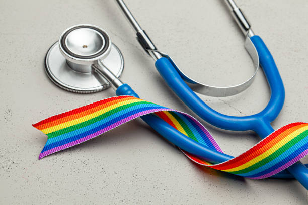 Stethoscope and LGBT rainbow ribbon pride symbol. Medical support after sex reassignment surgery. Grey background. stock photo