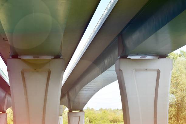 istock Bottom view of a huge flyover motorway, blue sky, large pillars with sunlight. 1176272538
