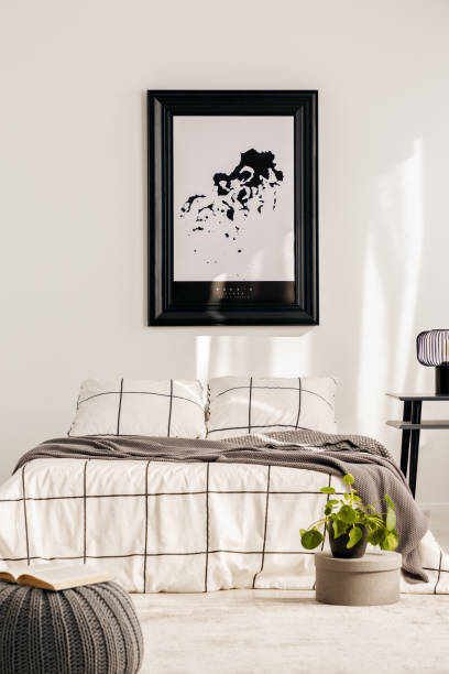 istock Industrial lamp on nightstand table next to king size bed in white bedroom interior 1176273381