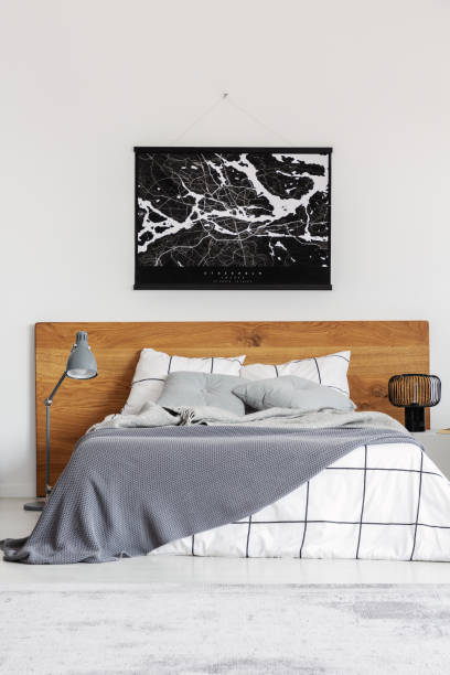 istock Black map on white wall above wooden headboard in simple bedroom interior 1176273386