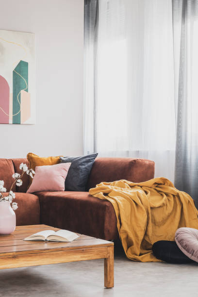istock Yellow blanket on brown corner sofa in trendy living room interior 1176273718