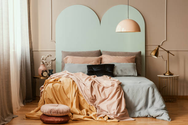 istock Pastel blue, pink and orange bedding on double bed in chic bedroom interior 1176275772