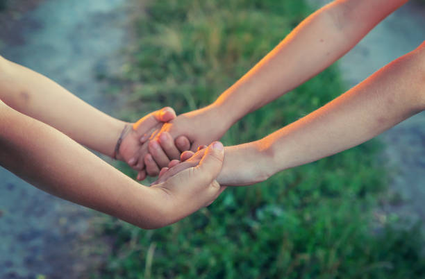 istock children hold hands together. People. Selective focus. 1176280141