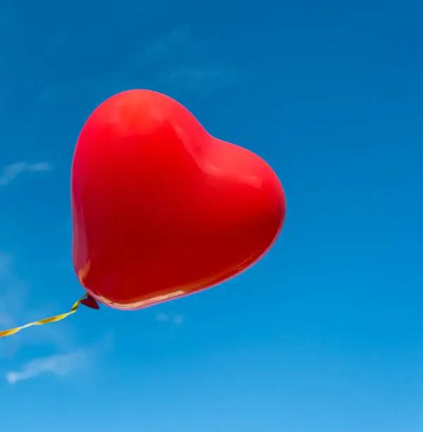 decorative red heart balloon in the blue sky