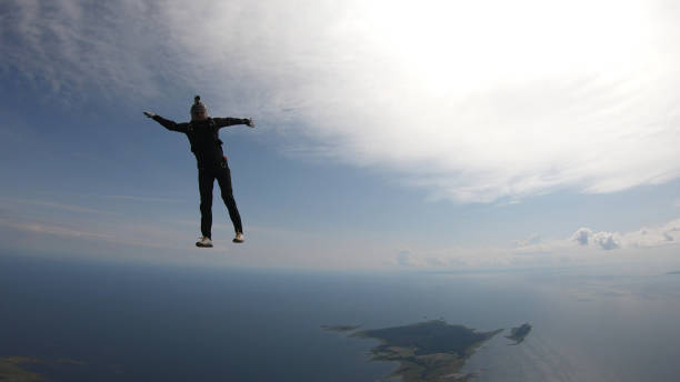 istock Skydiver falls through clear skies, in aerial flight 1176288103