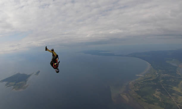 istock Skydiver falls through clear skies, in aerial flight 1176288112