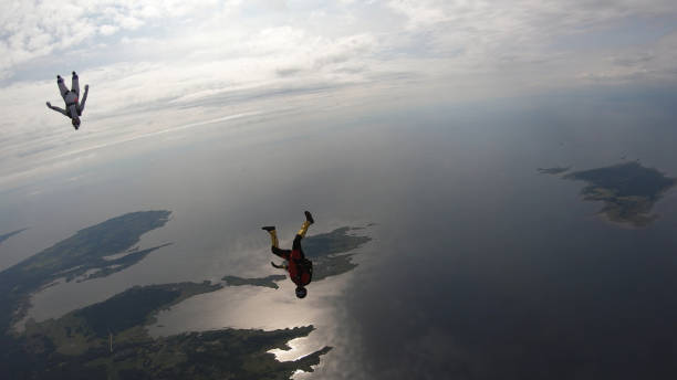 istock Skydivers fall through clear skies, in aerial flight 1176288125