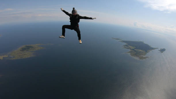 istock Skydiver falls through clear skies, in aerial flight 1176288127