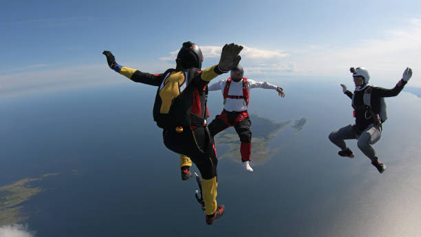 istock Skydivers fall through clear skies, in aerial flight 1176288791