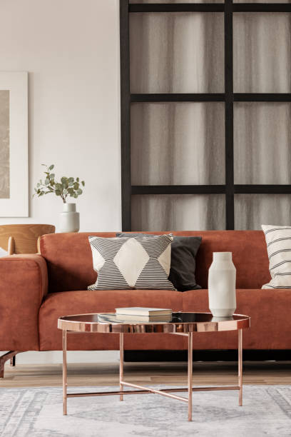 istock Stylish brown corner sofa with patterned pillows in elegant living room interior with mullions wall 1176289435