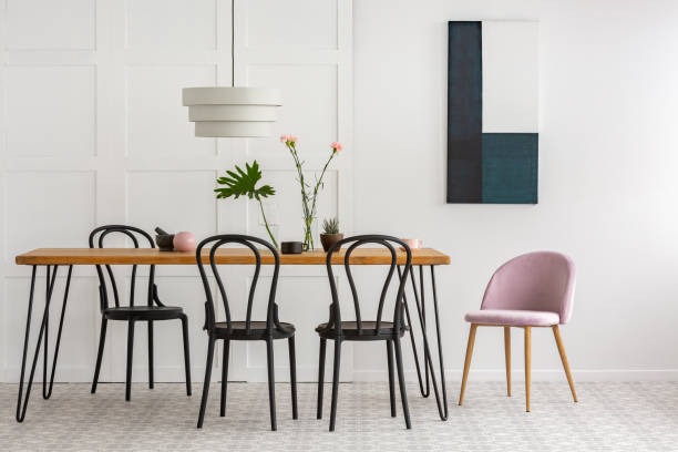 istock White lamp above wooden table with black chairs 1176289446