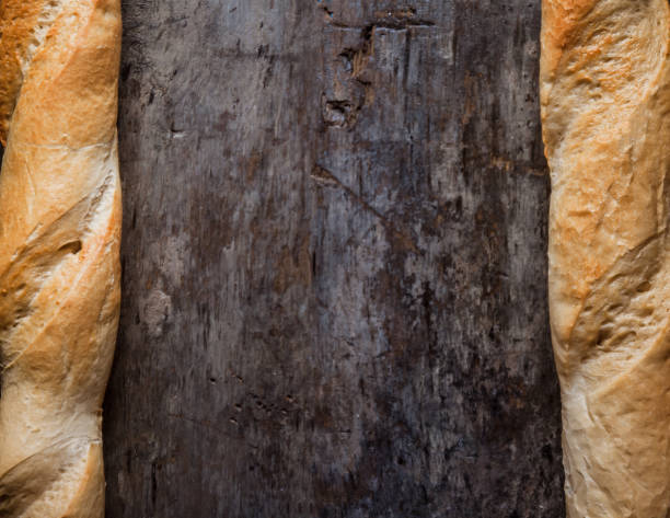 Fresh rosy baguettes on a dark wooden retro background. Top view, copy space