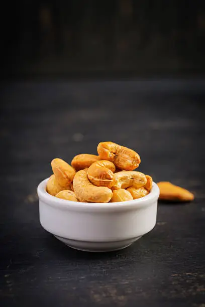 Cashews on dark wooden background. A handful of nuts.