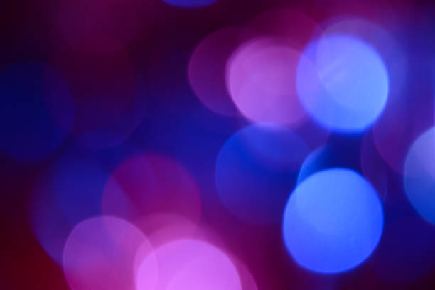 Bokeh. Holiday background. Christmas lights. Glitter. Defocused sparkles. New Year backdrop. Festive wallpaper. Blinks. Carnival. Bokeh retro style photo. Violet. Red. Blue. stock photo