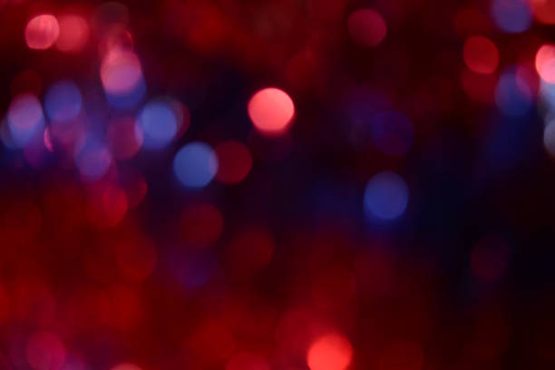 Bokeh. Holiday background. Christmas lights. Glitter. Defocused sparkles. New Year backdrop. Festive wallpaper. Blinks. Carnival. Bokeh retro style photo. Violet. Red. Blue.