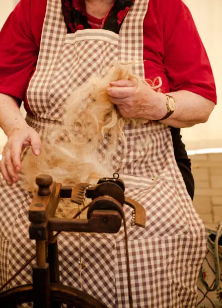 Photo of a elderly woman that spinning wool